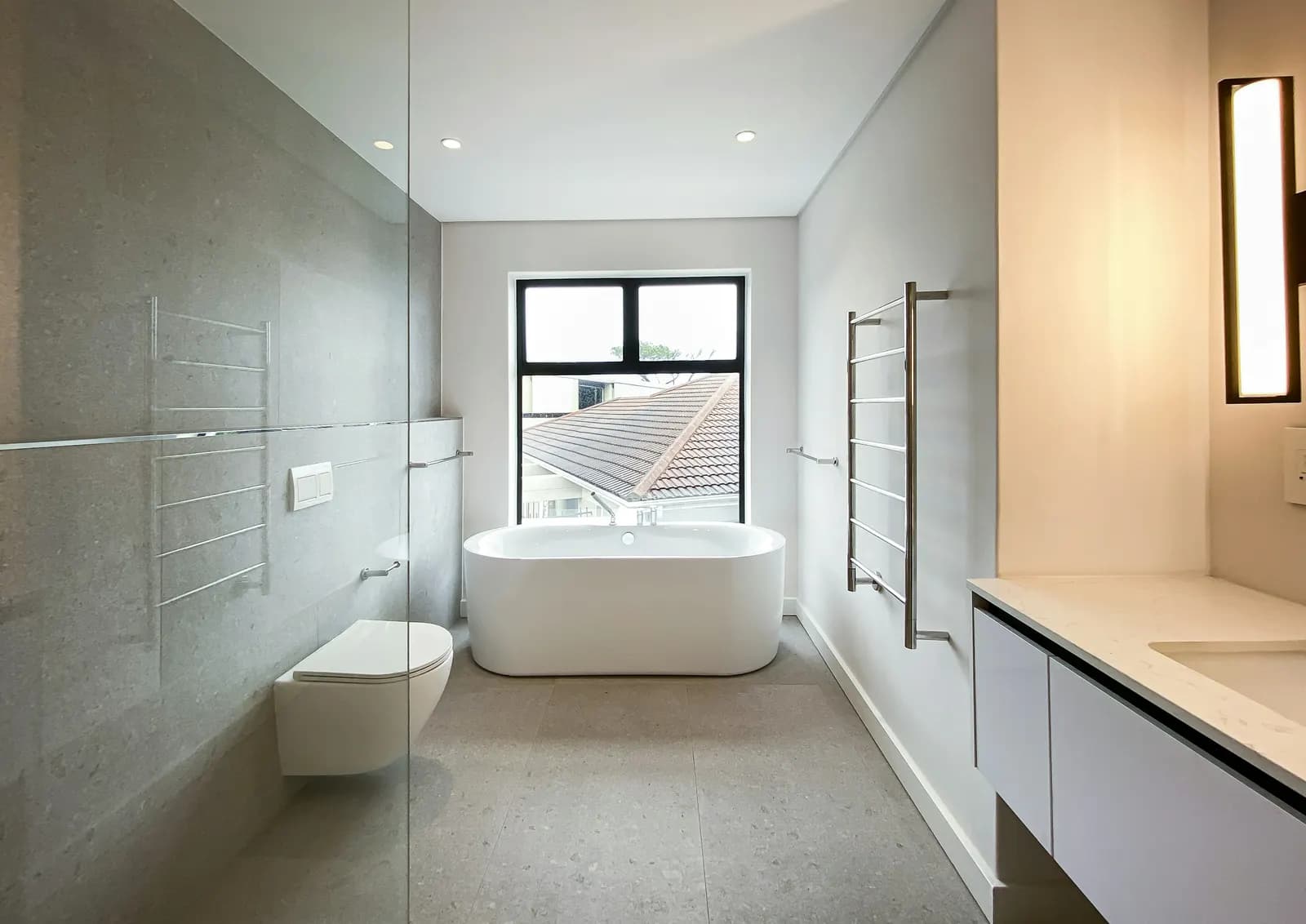 Baño luminoso con bañera exenta y toallero