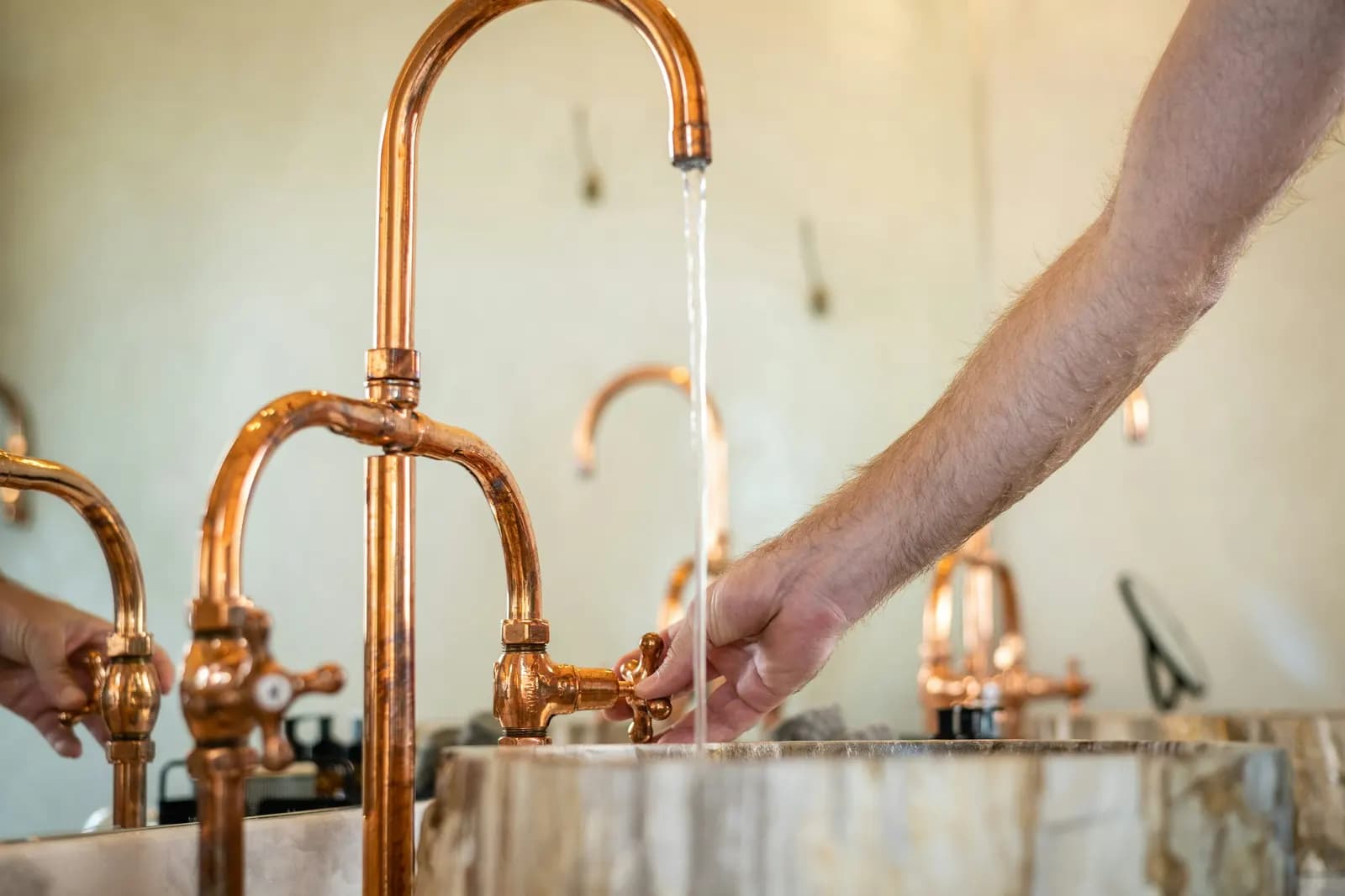 Manos bajo un grifo de latón en un lavabo