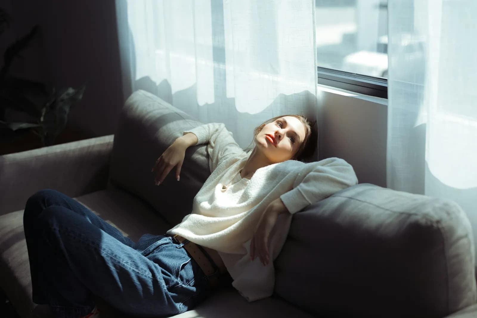Mujer descansando en un sofá con luz de tarde