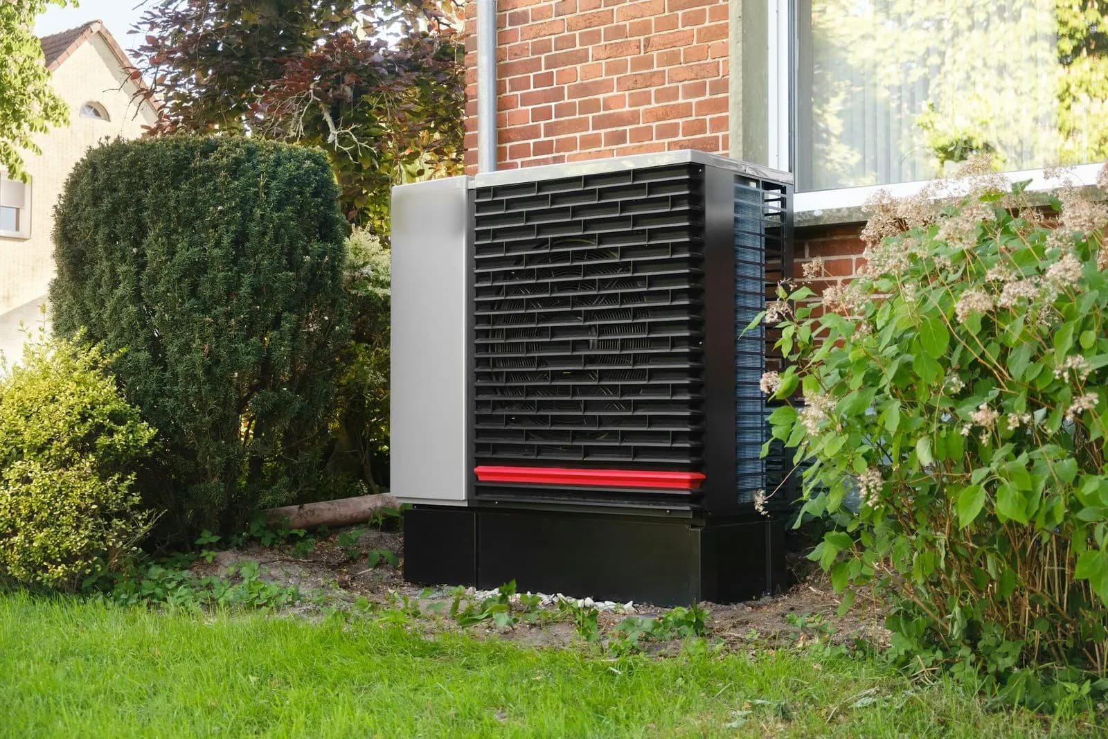 Bomba de calor exterior junto a una vivienda