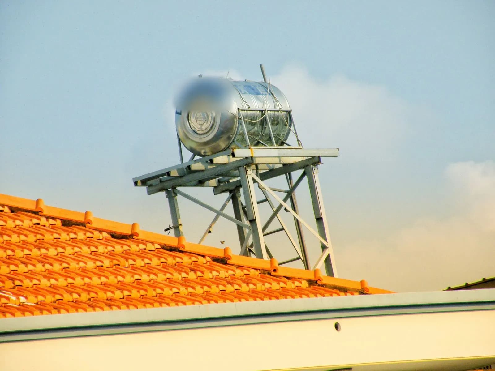 Equipo solar térmico con acumulador sobre un tejado de teja
