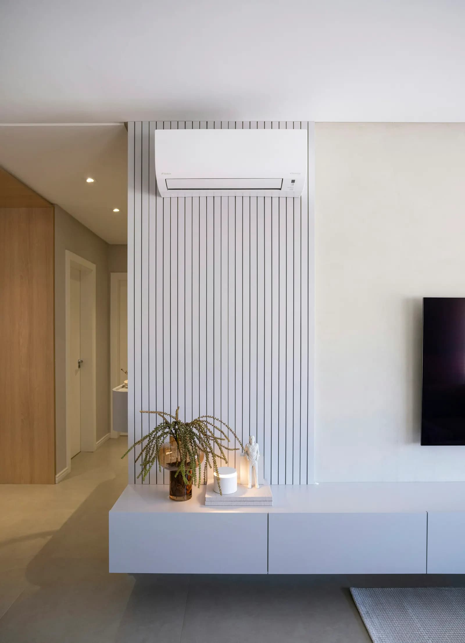 Split de aire acondicionado sobre una pared de listones blancos