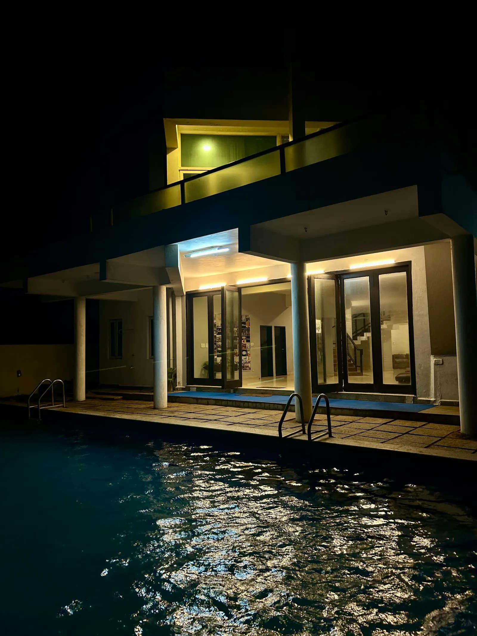 Villa contemporánea con piscina iluminada de noche