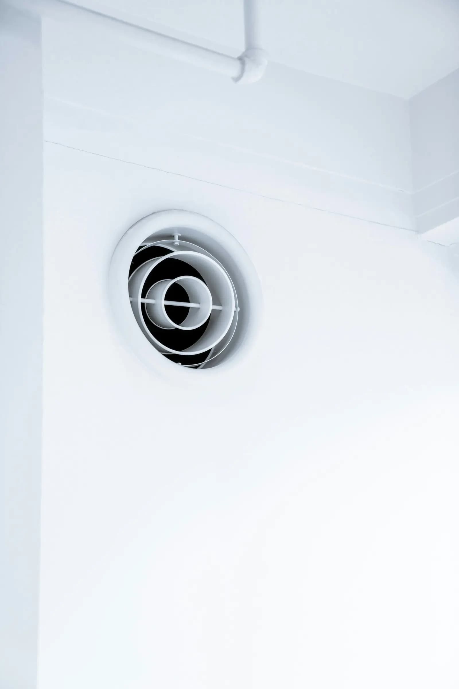 Boca de ventilación circular integrada en un techo blanco